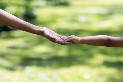 Close-up of hand holding hands outdoors