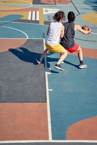 Rear view of friends playing basketball