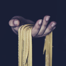 Close-up of human hand holding raw pasta dough