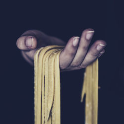 Close-up of human hand against black background