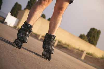 Low section of man rollerskating on road