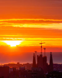 Silhouette buildings against sky during sunset