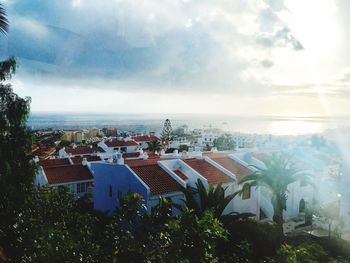 High angle view of town by sea against sky