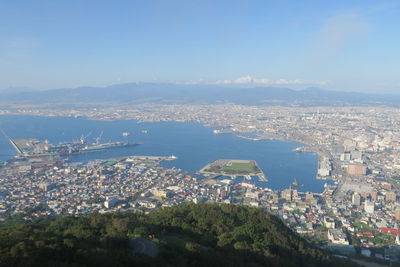 High angle view of city by sea against sky