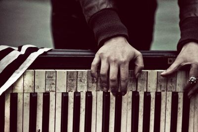 Cropped image of woman playing damaged piano