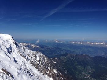 Scenic view of snowcapped mountains against blue sky