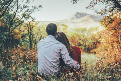 Rear view of couple sitting on land