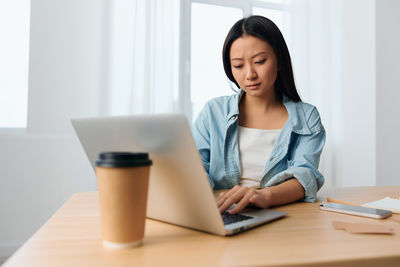 Portrait of young businesswoman working at table