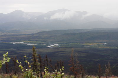 Scenic view of land and mountains against sky