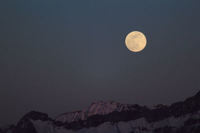 Scenic view of snowcapped mountains against clear sky at night