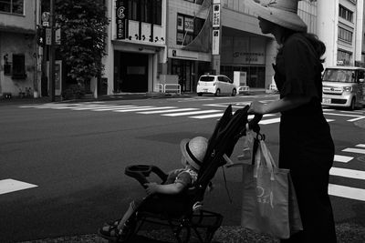 Woman with umbrella on street in city