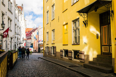 People walking on street amidst buildings in city