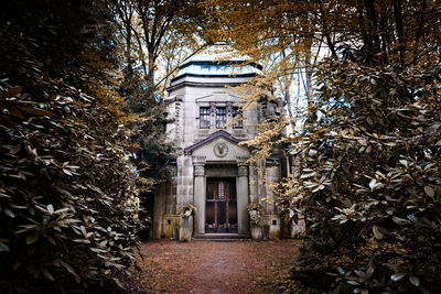 Trees by building during autumn