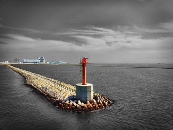 Lighthouse by sea against sky