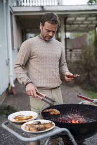 Man preparing meat on grill