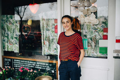 Portrait of smiling young woman standing in store