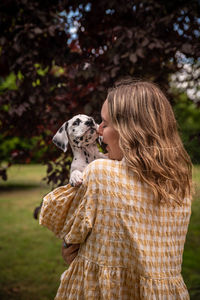 Rear view of woman with dog on field