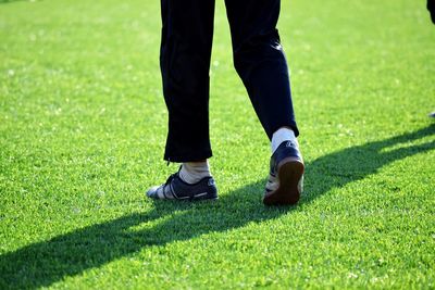 Low section of man standing on grassland