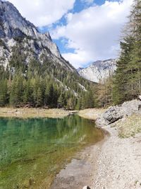 Scenic view of lake by mountains against sky