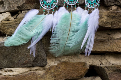 High angle view of feather hanging on stone wall