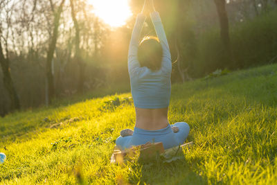 Rear view of woman with umbrella on field