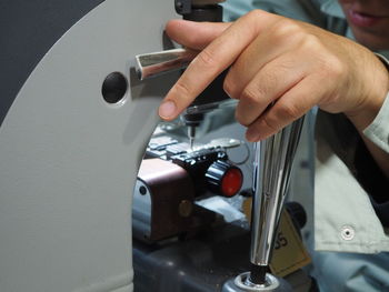 Cropped image of locksmith making key on machinery