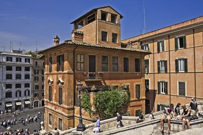 People on street against buildings in city