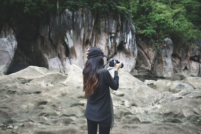 Rear view of woman taking photographs