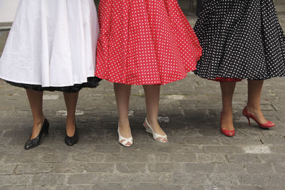 Low section of women standing on cobbled street