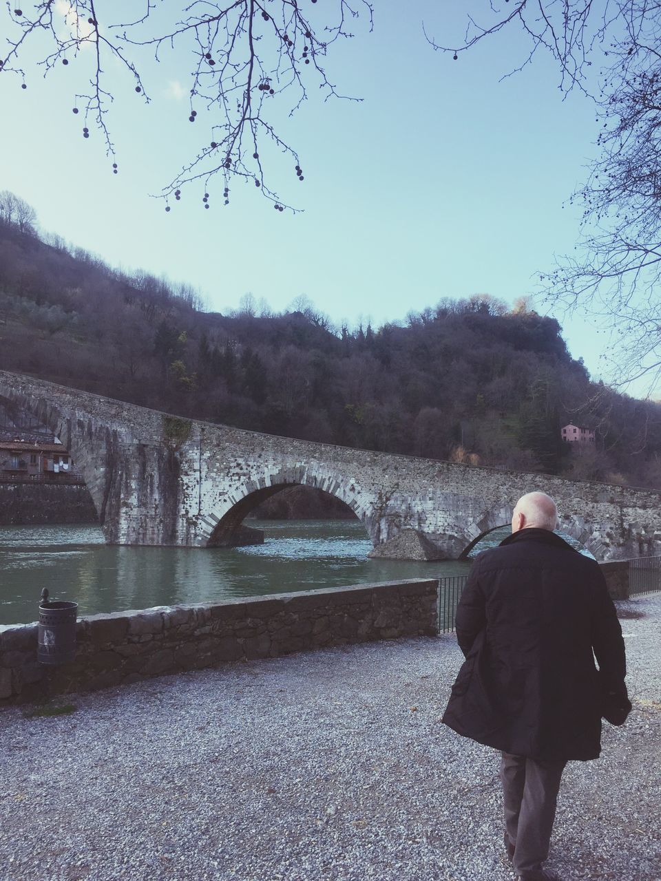 REAR VIEW OF WOMAN WALKING ON RIVERBANK