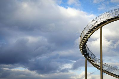 Low angle view of steps against cloudy sky