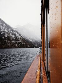 Cropped image of boat in lake against sky during winter