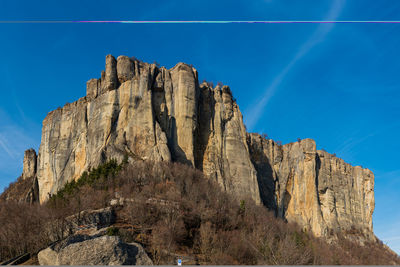 Low angle view of rock formation against blue sky