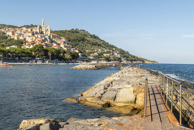 Scenic view of sea by buildings against sky