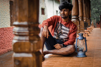 Smiling man looking away while sitting outdoors