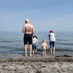 Father with three sons on the beach.