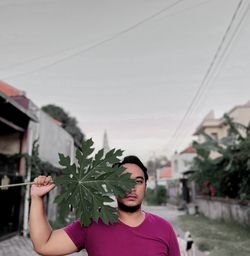 Portrait of man holding plant