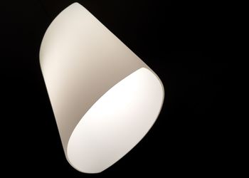 Low angle view of illuminated light bulb against black background