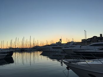 Boats in harbor at sunset