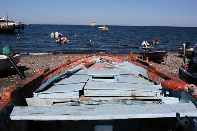 Boats moored on sea against clear sky