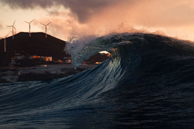 Scenic view of a wave splashing against sky during sunset