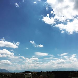 View of cityscape against cloudy sky