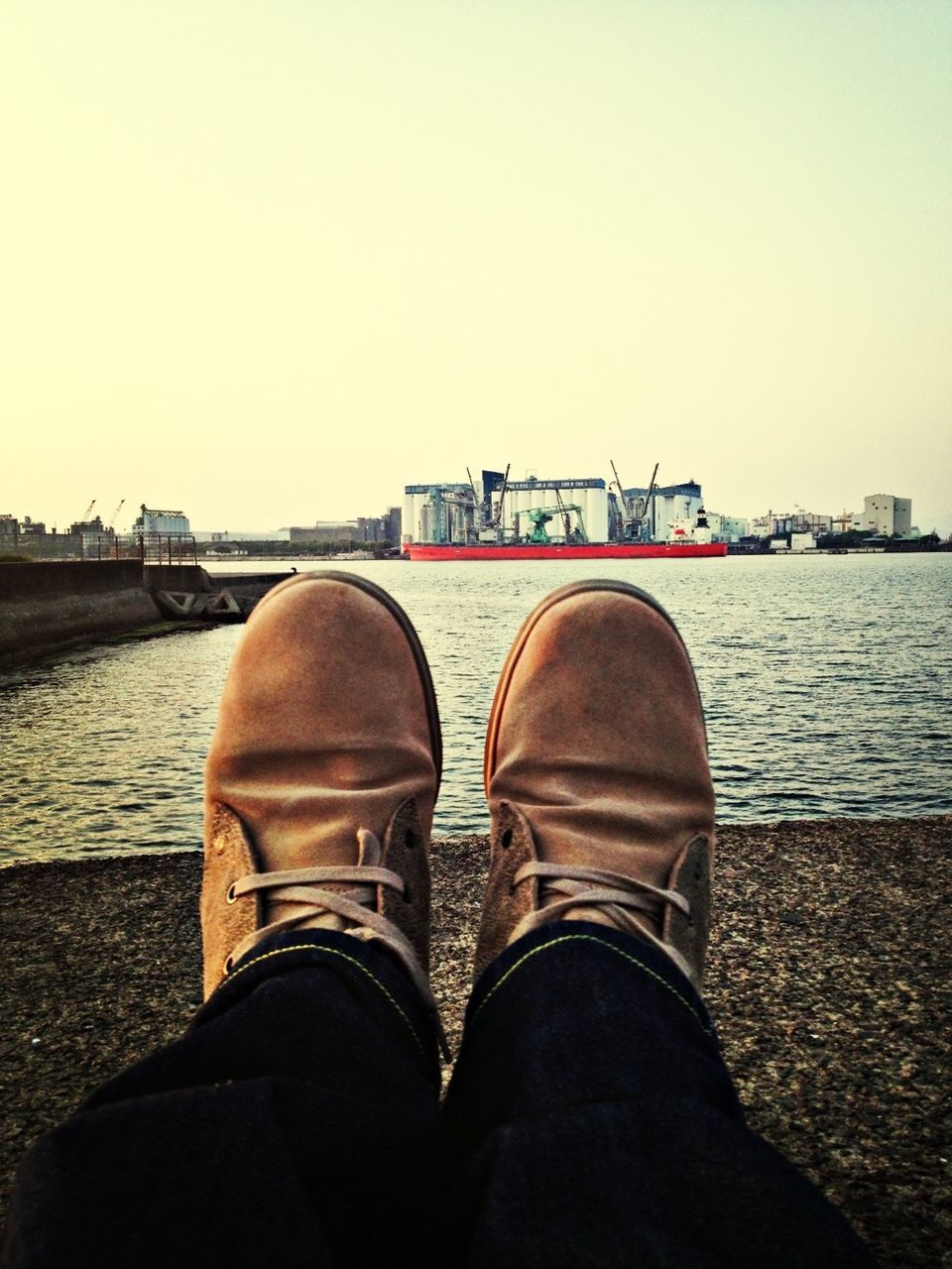 low section, person, shoe, water, personal perspective, men, standing, lifestyles, clear sky, copy space, leisure activity, sea, footwear, river, sky, relaxation, jeans