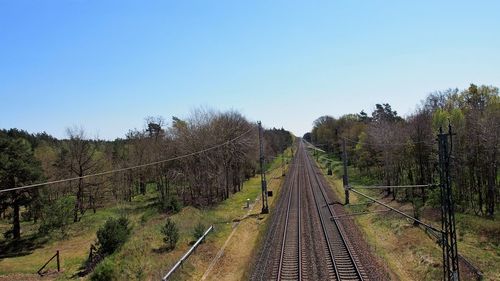 High angle view of train rails on landscape against blue sky