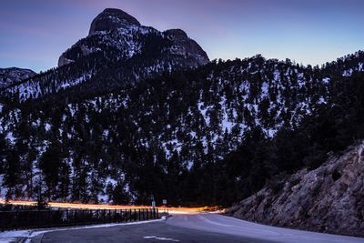 Long exposure of vehicles on road by snowcapped mountains