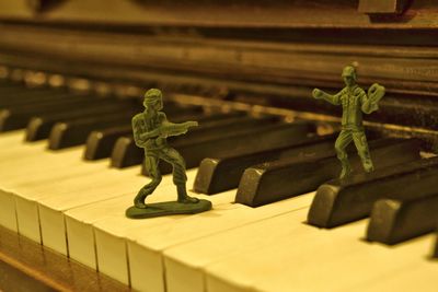 Close-up of toy soldiers on piano keys