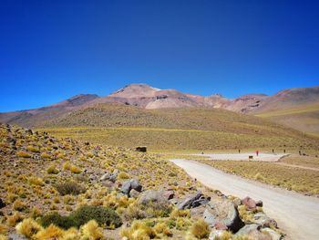 Scenic view of desert against clear blue sky