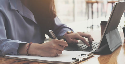 Midsection of man using laptop on table