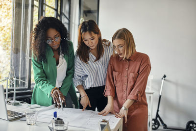 Businesswomen having a meeting in office with wind turbine models on table