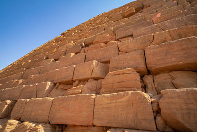 Low angle view of stone wall against clear sky